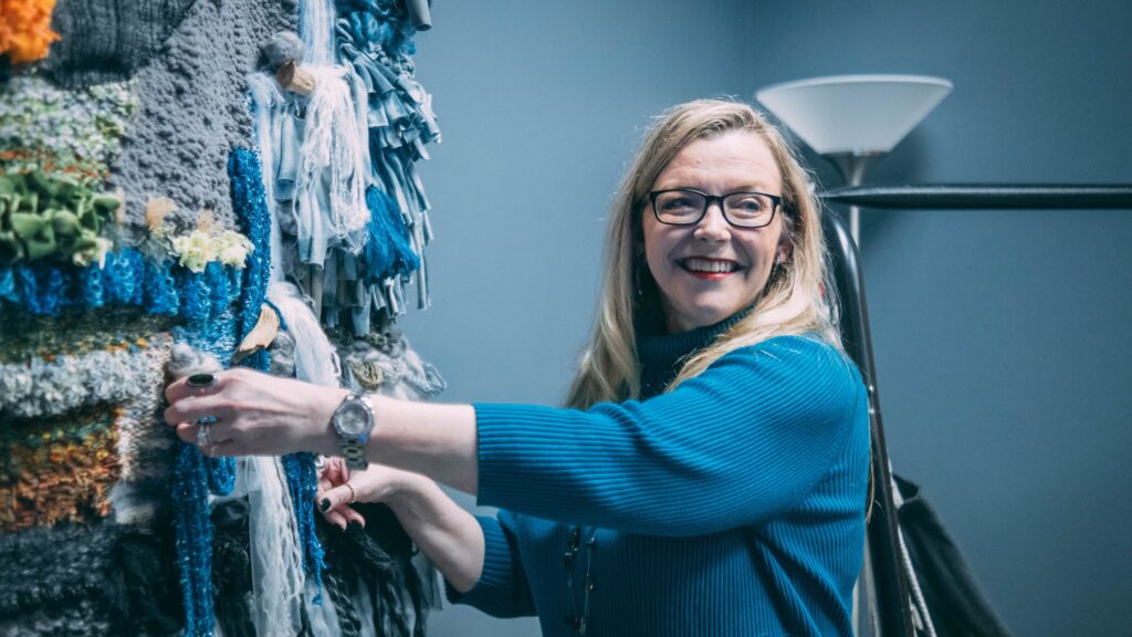 Lisa Williams touching the textured wall in the new sensory room